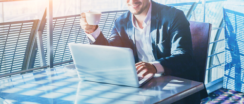 man drinking coffee and sending emails