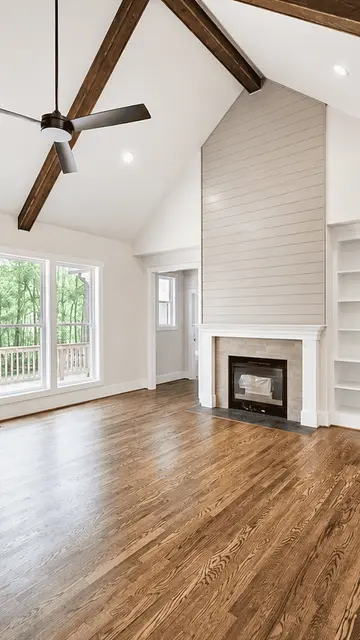 A great room with a fireplace and built-in shelves