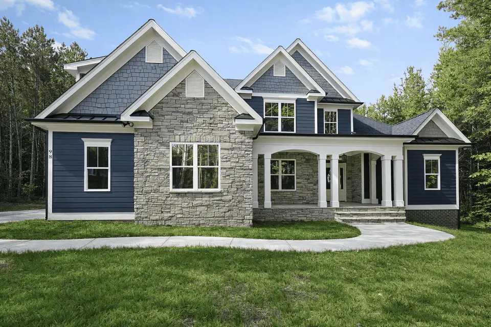 A Travars home with navy siding, a stone front and a covered porch